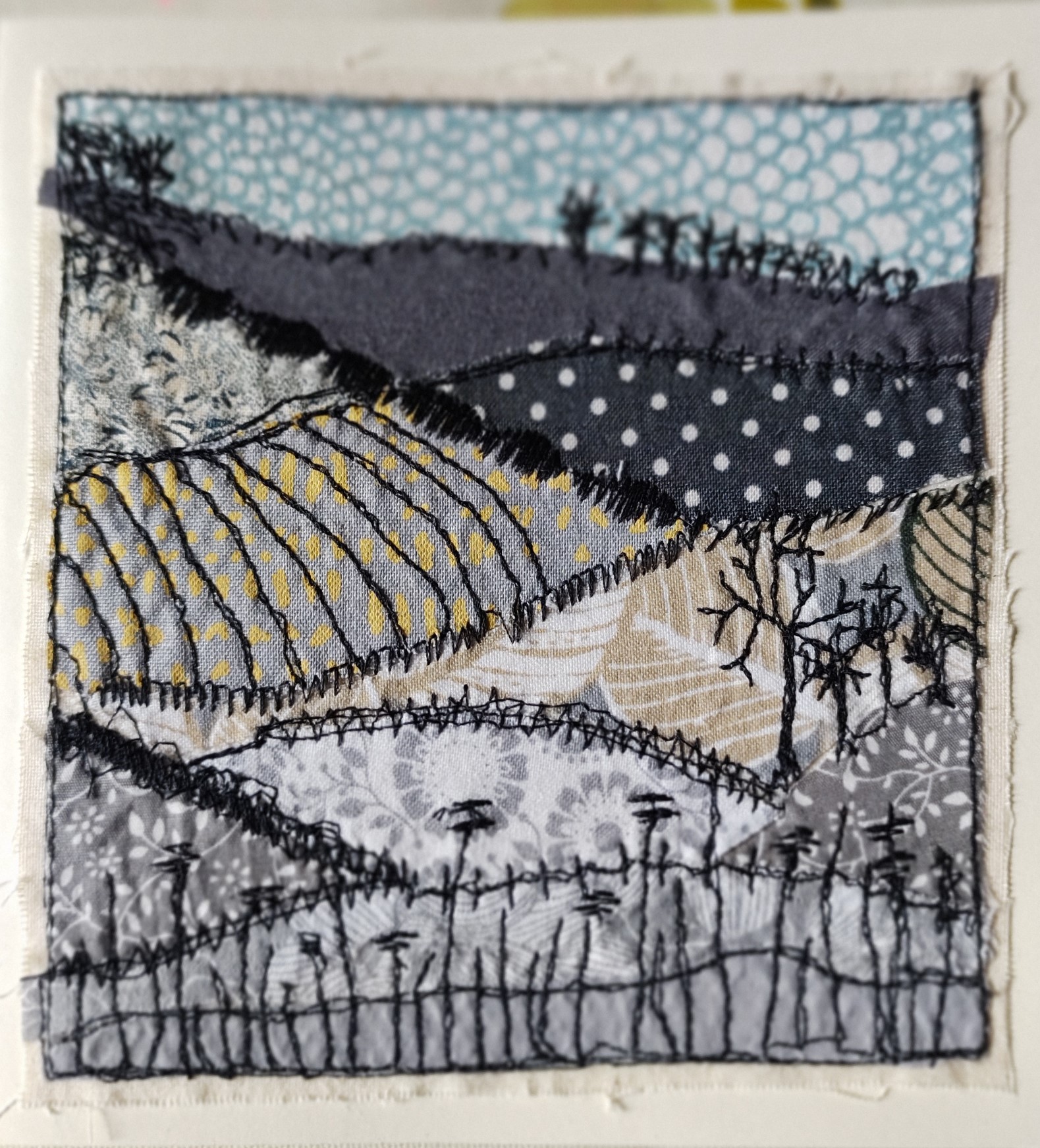 Freehand machine sewn gift card depicting grey themed field scene