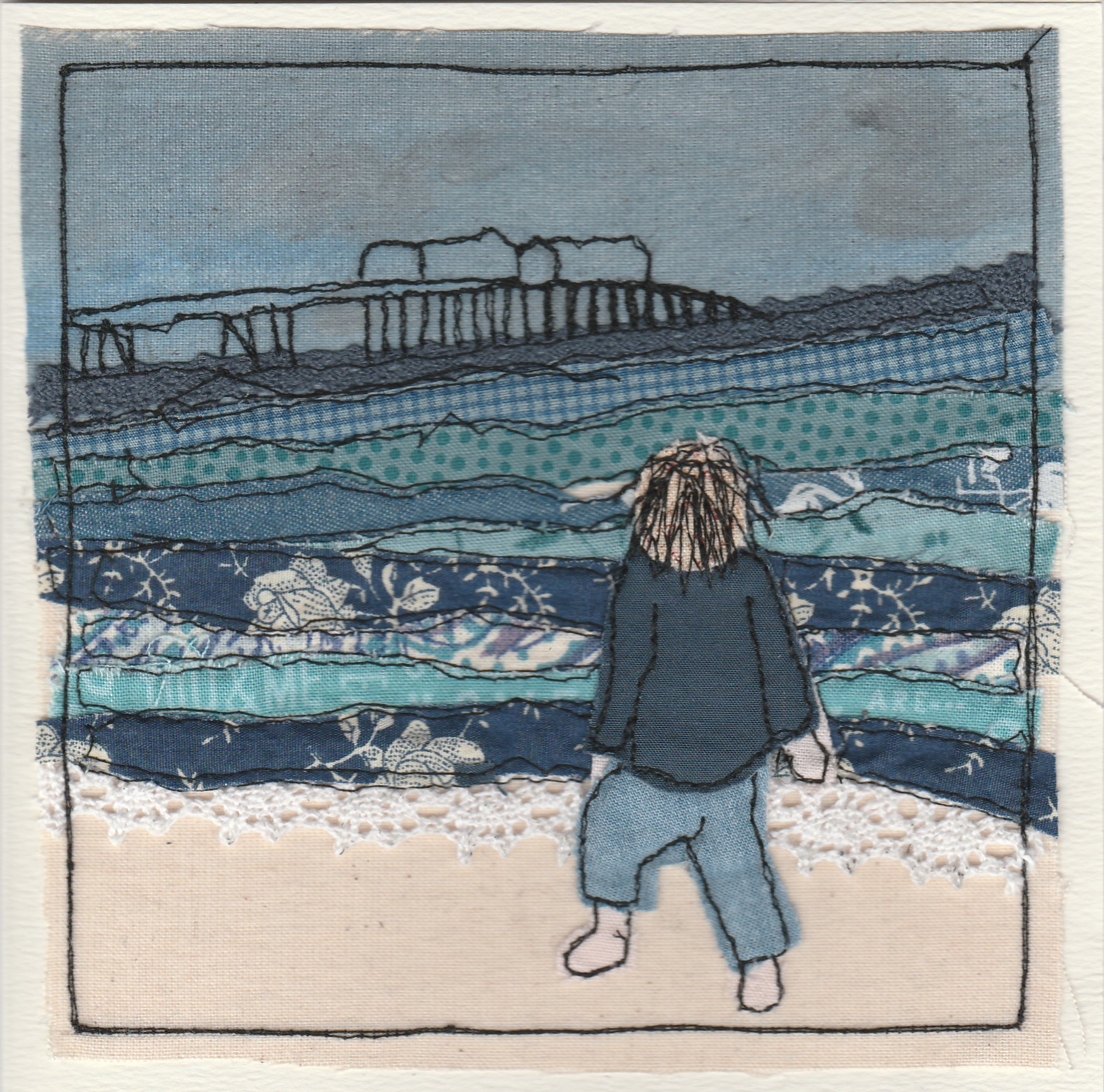 Freehand machine sewn gift card with woman on beach looking at pier