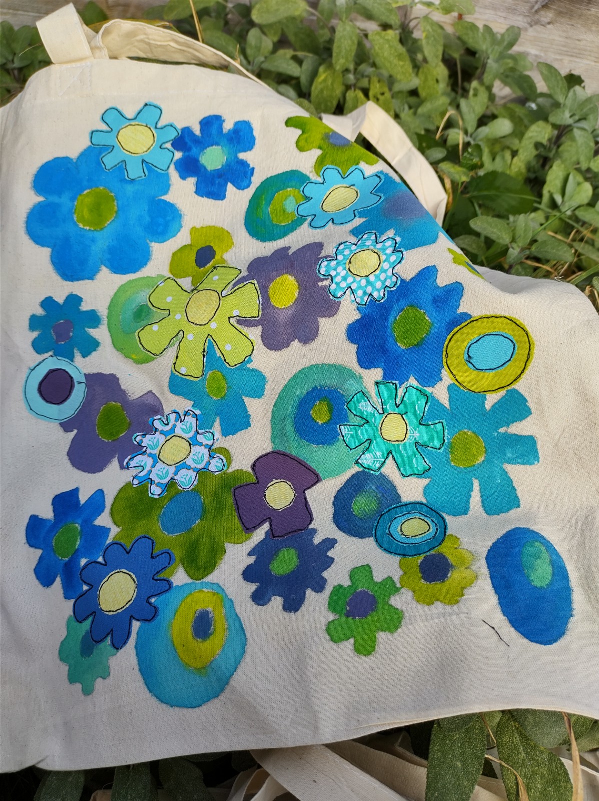 Tote bag with freehand machine sewn blue flower design.